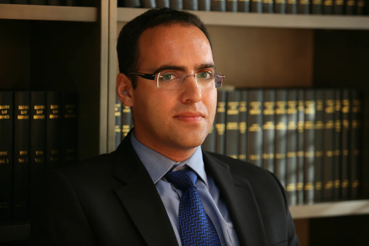 עו״ד אורי טשקורי בחליפה במשרדו